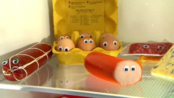 In einem Kühlschrank liegen verschiedenen Lebensmittel mit aufgeklebten Augen.  
