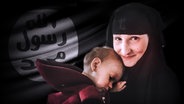 Leonora trägt ein Kopftuch und hält ein Kind auf dem Arm. Im Hintergrund eine Flagge mit arabischen Schriftzeichen. © NDR/Fritz Gnad Foto: Fritz Gnad