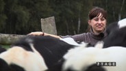 NDR Reporterin Johanna Leuschen treibt Kühe vor sich her.  