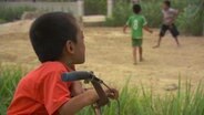 Long Thanh guckt seinen Freunden beim Fußball spielen zu.  