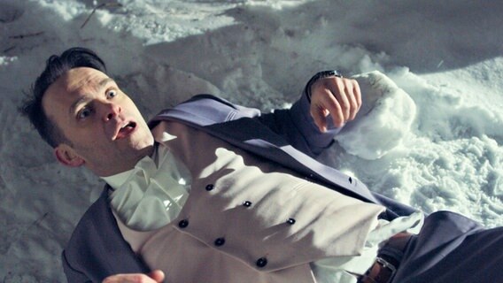 Ein Mann liegt auf dem Rücken im Schnee und guckt entsetzt nach oben. © NDR/Viafilm AS 