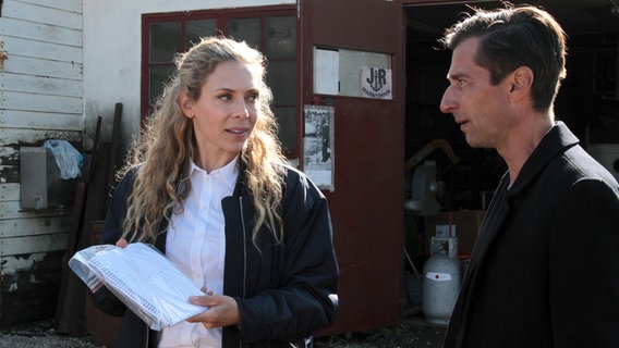 Maria Wern (Eva Röse) und ihr Kollege Arvidsson (Peter Perski) suchen in der Werkstatt des vermissten Bergungsexperten Jonathan Rogers nach Spuren. © ARD Degeto/Warner Bros./Cologne Film/Ulrika Malm 