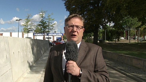 Ein Journalist vor der Mauer in Staßfurt Sachsen-Anhalt.  