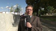 Ein Journalist vor der Mauer in Staßfurt Sachsen-Anhalt.  