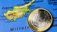 Ein-Euro-Münze auf Zypern-Landkarte, Haushaltsdefizit auf Zypern © picture alliance Foto: CHROMORANGE / Christian Ohde