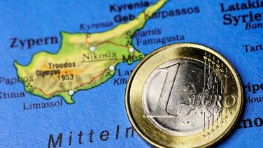 Ein-Euro-Münze auf Zypern-Landkarte, Haushaltsdefizit auf Zypern © picture alliance Foto: CHROMORANGE / Christian Ohde