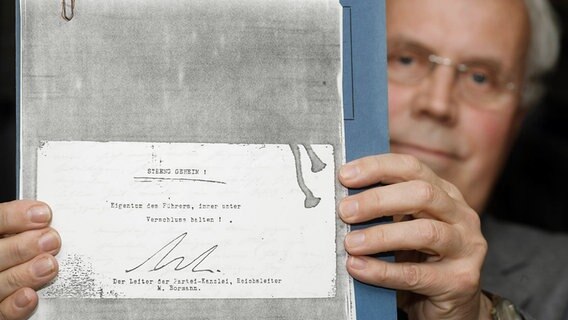 Archivdirektor Josef Henke vom Koblenzer Bundesarchiv zeigt die Kopie des Deckblattes der von Konrad Kujau gefälschten Hitler-Tagebüchern. © Thomas Frey, dpa Foto: Thomas Frey