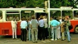Journalisten drängen sich vor einem Bus  
