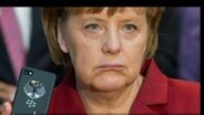 Angela Merkel hält ein Smartphone in der Hand (bearbeitetes Bild).  