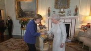 Angela Merkel verbeugt sich vor der Queen.  