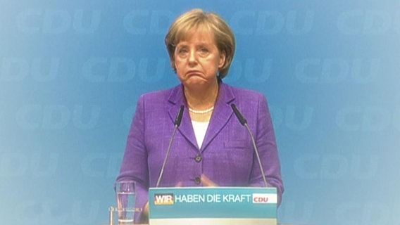 Bundeskanzlerin Angela Merkel zieht die Mundwinkel nach unten.  
