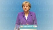 Bundeskanzlerin Angela Merkel zieht die Mundwinkel nach unten.  