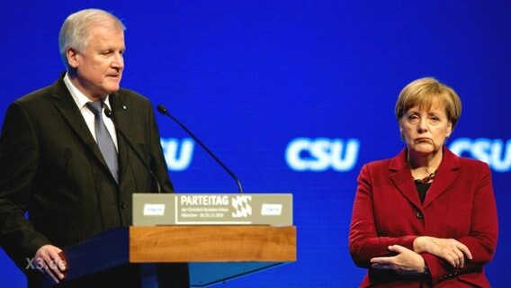 Angela Merkel steht neben Horst Seehofer.  