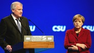 Angela Merkel steht neben Horst Seehofer.  