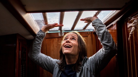 Tessa (Sabine Urban) versucht panisch, aus einer Kajüte zu entkommen. Dabei schlägt sie mit den Händen über dem Kopf gegen die Kajütendecke. © ARD/Thorsten Jander 