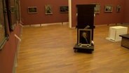 Ein Gemälde wird durch ein Museum gefahren. © NDR/Kulturjournal 