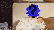 Eine Person, deren Gesicht von einem blauen Klecks und einem schwarzen Fragezeichen verdeckt wird, sitzt auf der Couch und hält ein Baby im Arm. © Benjamin Kahlmeyer 