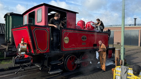 Drei Männer putzen eine historische Bahn. © NDR/Jörg Teiwes 