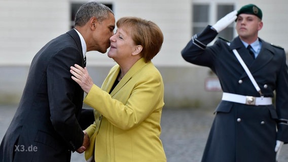 Barack Obama und Angela Merkel begrüßen sich.  