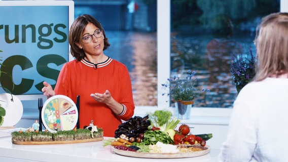Ernährungs-Doc Silja Schäfer erklärt ihrer Patientin mit Lebensmitteln und Bildern, was sie essen sollte, um gesünder zu werden. © Screenshot 