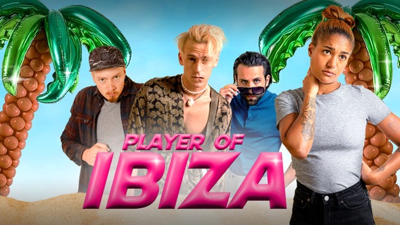 Die Player Tim (Bruno Alexander), Anthony (Emil Belton) und Abdel-Rahman (Arman Kashani) stehen zwischen künstlichen Palmen, rechts davor Regisseurin Amelie (Larissa Sirah Herden). © NDR/Kleine Brüder/Hannah Aders/Nick Hentrich 