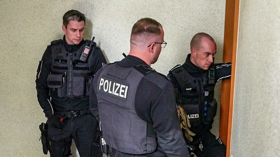 Polizisten vor einer Wohnungstür. © NDR/Thomas Eichler 