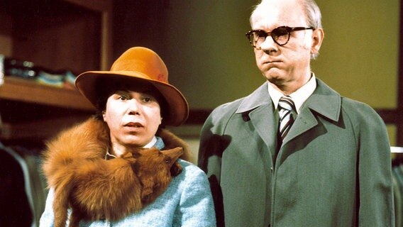 Eine Dame mit Hut und Pelzkragen und ein Herr mit Brille und einem Mantel bekleidet blicken ratlos drein. © Radio Bremen 