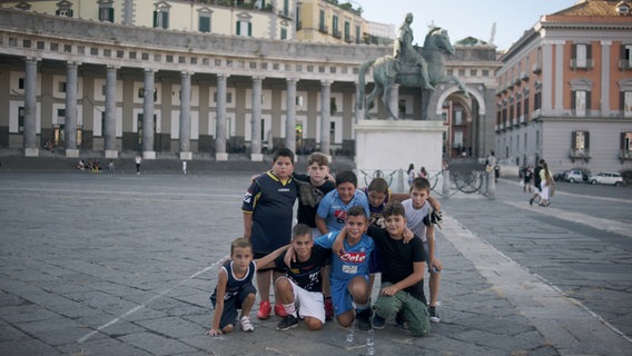Eine Gruppe von Jungen posiert für das Foto auf einem Marktplatz. © Neue Visionen Filmverleih 