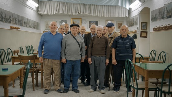 Eine Gruppe älterer Herren steht in einem Gastraum. © Neue Visionen Filmverleih 