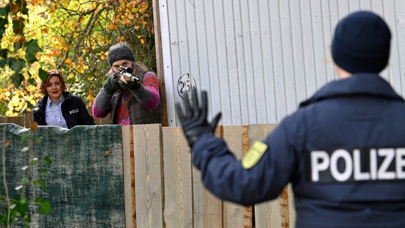 Die Hausmeisterin des Schießplatzes Karen Moll (Lucy Wirth, h.r.) hat sich im Wald verschanzt. Julia Demmler (Wendy Güntensperger, h.l.) und Nele Fehrenbach (Floriane Daniel, r.) versuchen zu deeskalieren. © ARD/Laurent Trümper 