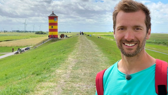 Moderator Daniel Aßmann vor dem Pilsumer Leuchtturm. © WDR/Dieter Schug 