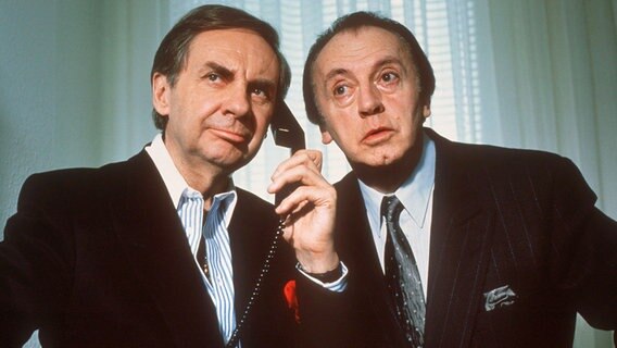 Zwei Herren lauschen an einem Telefonhörer. © NDR 