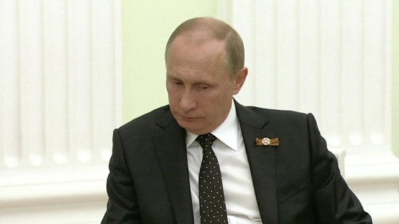 Wladimir Putin blickt zu Boden.  