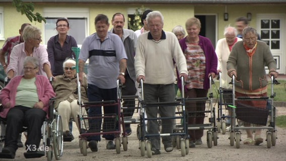 Eine Gruppe Rentner läuft auf die Kamera zu  