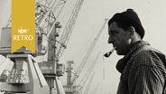 Hafenarbeiter mit Pfeife vor einem Ladekran (1962, Hamburger Hafen).  