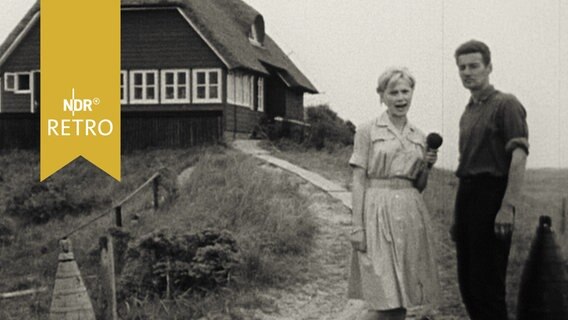 Reporterin mit dem Vogelwart vor der Warft auf der Vogelschutzinsel Memmert 1962  