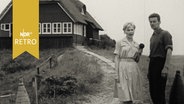 Reporterin mit dem Vogelwart vor der Warft auf der Vogelschutzinsel Memmert 1962  