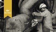 Arbeiter an der Ablassrinne eines Hochofens bei der Arbeit 1962  