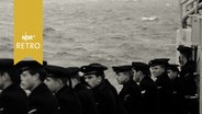 Drei Kreuzer bei einer Flottenparade, im Vordergrund Seeleute beim Zuschauen (1962)  
