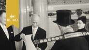 Bürgermeister Paul Nevermann empfängt von einem Schornsteinfeger eine Urkunde der Hummel-Stiftung (1963).  