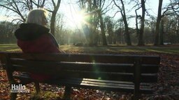 Angelika Angerstein sitzt auf einer Parkbank.