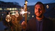 Jakob Leube mit einer Wunderkerze auf dem Balkon  