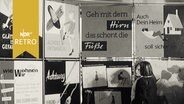Verschiedene Plakate mit Warnhinweisen für den Haushalt in einer Ausstellung 1965  