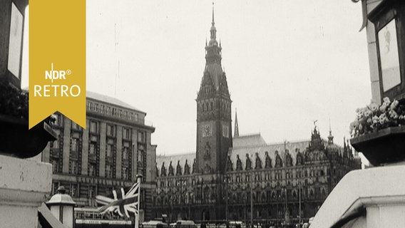 Blick vom Jungernstieg auf das Hamburger Rathaus 1965 mit britischer Flagge im Vordergrund  