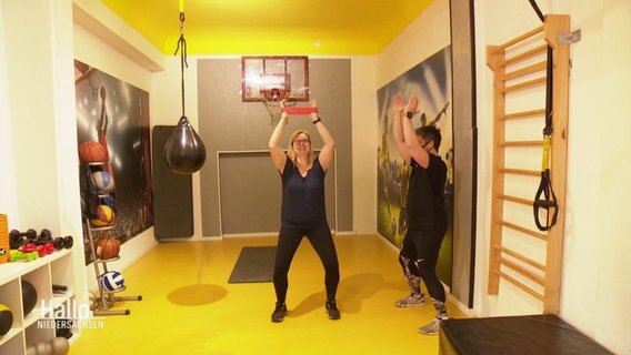 Silke Dormann macht Sportübungen während einer Einzelstunde mit ihrem Trainer.  