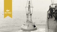 Tonne wird von einem Schiff zu Wasser gelassen (Auf See 1963)  