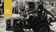 Bauer auf einem kleinen Trecker bei Messe (1965)  