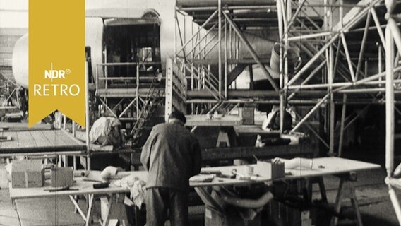 Flugzeugrumpf in einer Fabrikhalle in Bremen mit Gerüsten außenrum (1965)  