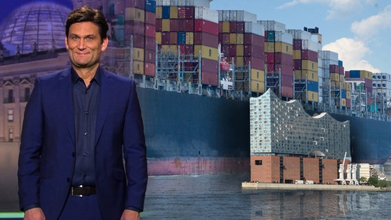Christian Ehring, dahinter ein Containerschiff in Hamburg.  