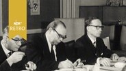 Podium der Landesressekonferenz Kiel 1965 mit drei Männern  